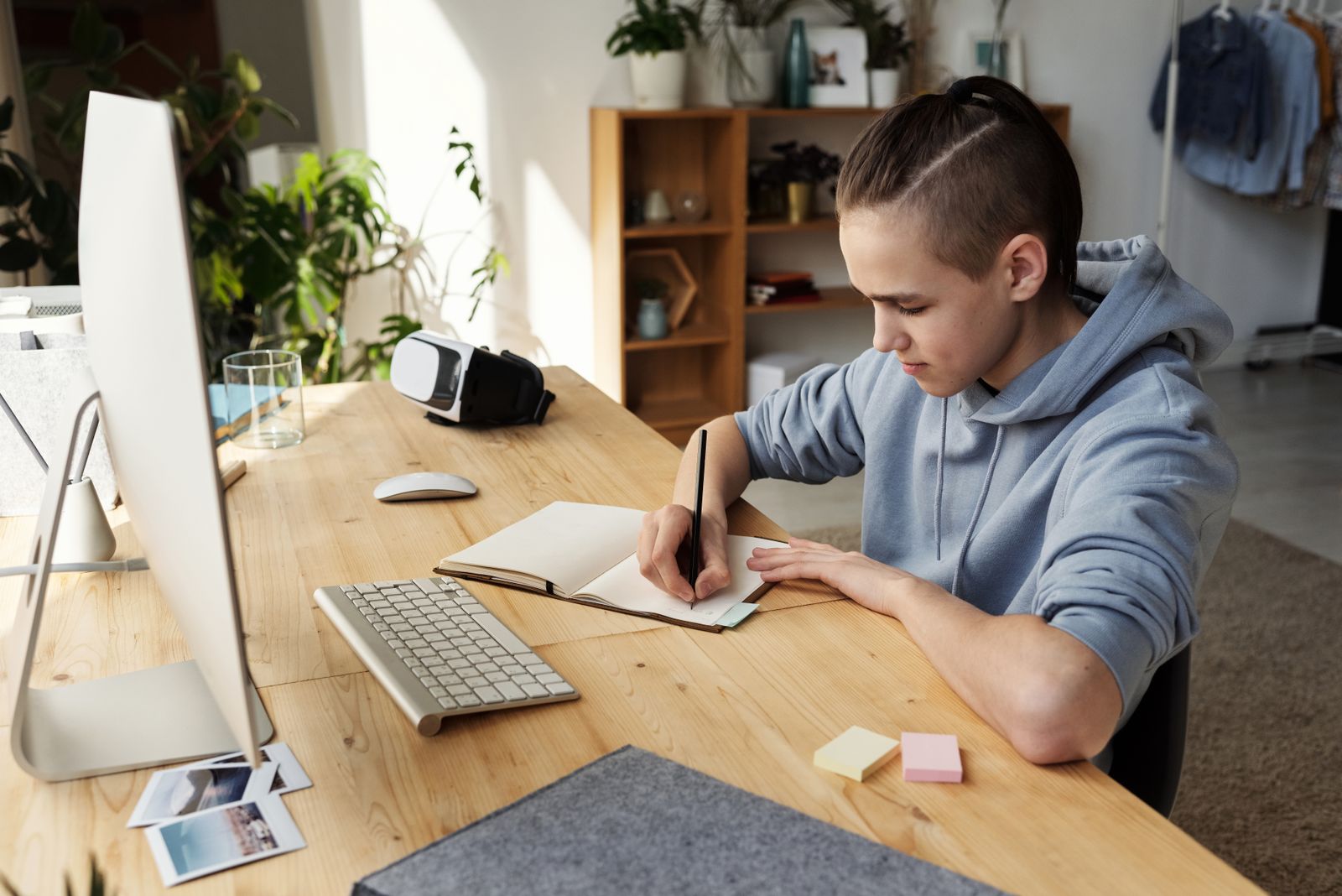 Teenager writing in a notebook at a desk
